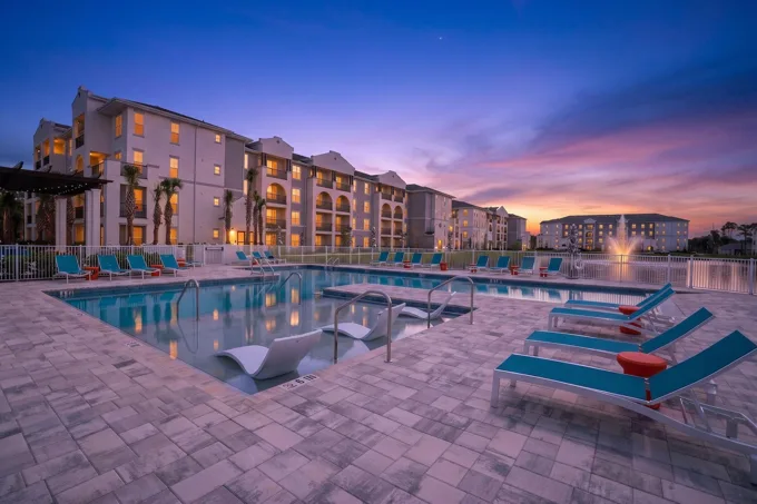 Swimming pool and apartment buildings at dusk at Entrada Apartments, Cape Coral