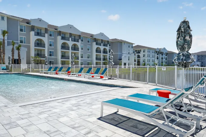 Poolside loungers and apartment buildings at Entrada Apartments, Cape Coral