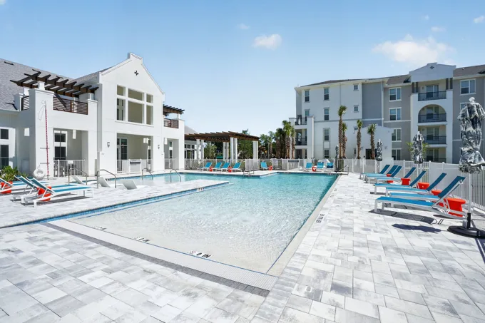 Clubhouse and swimming pool in daylight at Entrada Apartments, Cape Coral