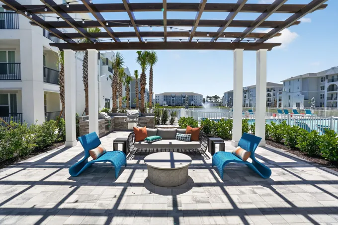 Shaded poolside seating beneath a pergola at Entrada Apartments, Cape Coral