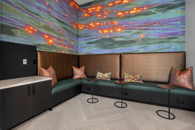 Lounge seating beneath a colorful mural at Entrada Apartments, Cape Coral