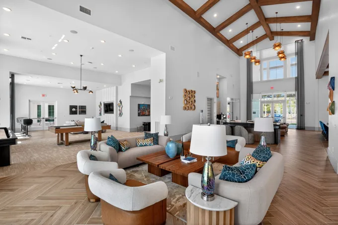 Clubhouse lounge beneath exposed wood beams at Entrada Apartments, Cape Coral