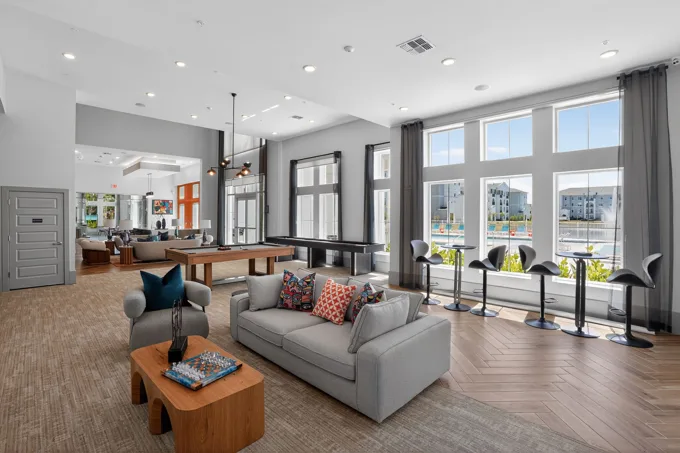 Clubhouse seating beside tall windows at Entrada Apartments, Cape Coral