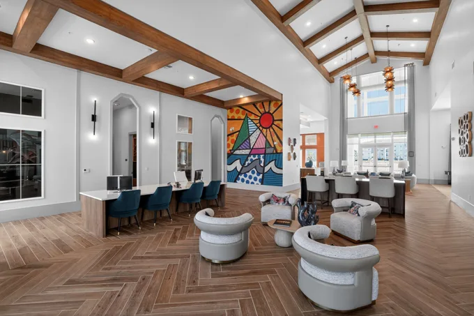 Clubhouse interior with wood beams and colorful artwork at Entrada Apartments, Cape Coral