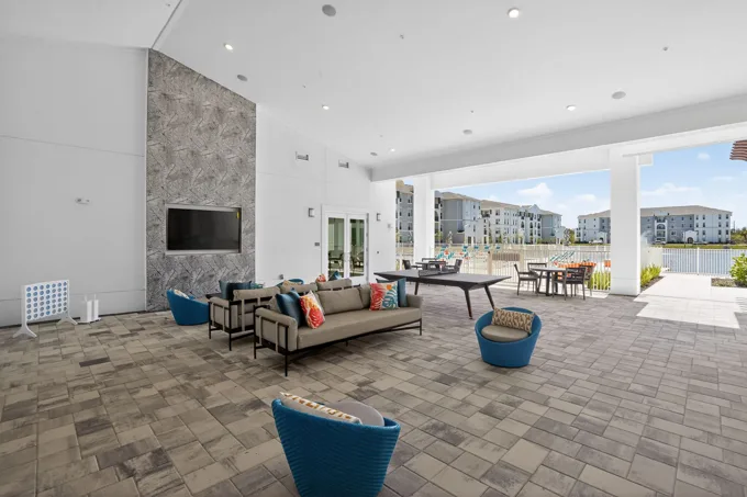 Covered outdoor lounge beside the pool at Entrada Apartments, Cape Coral