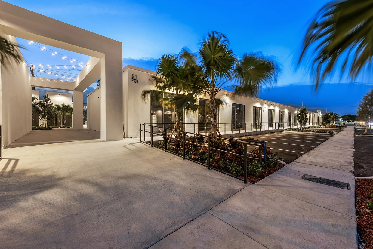 Illuminated courtyard walkway and palm trees at Thrive Art District, Fort Lauderdale