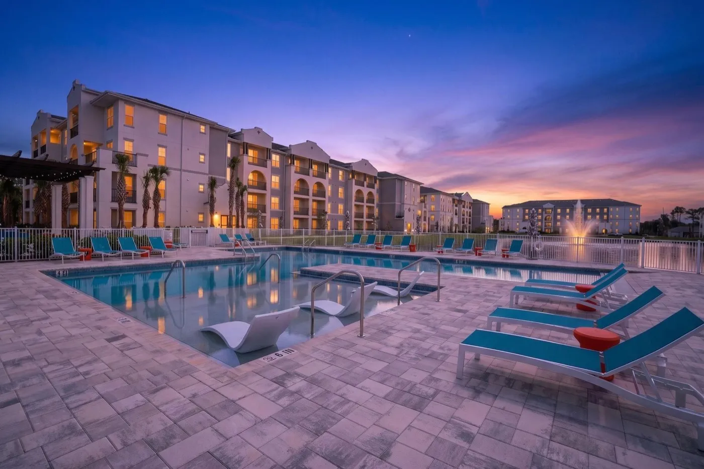 Entrada Apartments and its pool courtyard at dusk